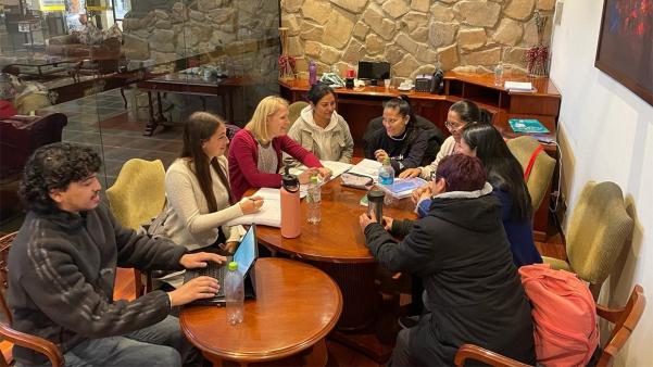 UVA researcher sits around table with parents in Bolivia
