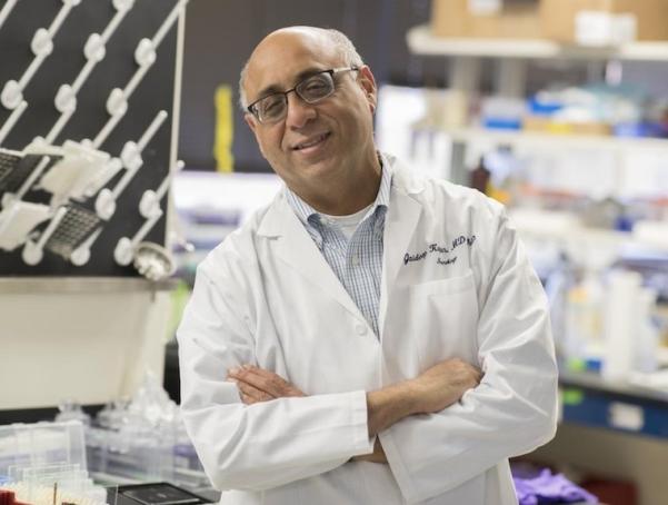 Jaideep in white coat in front of lab space