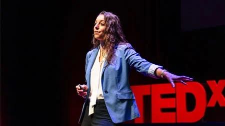 Meghan Puglia in front of TEDx sign