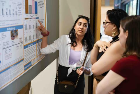 Students discuss research poster.